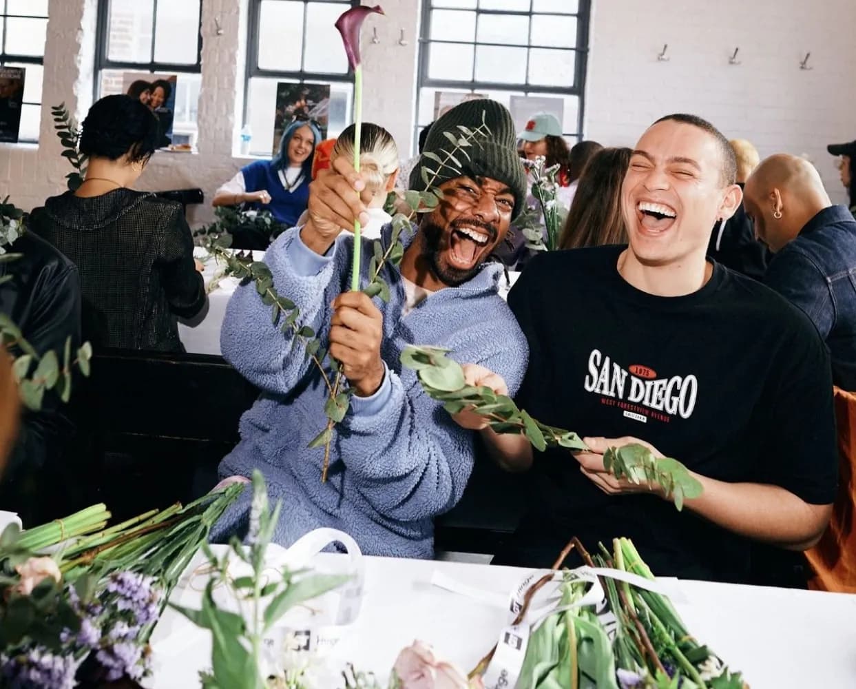 Two participants laughing during a flower arranging workshop